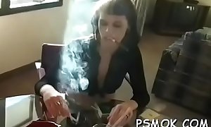 Horny babe smoking while giving a fellatio to her man